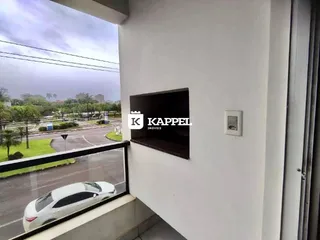 Vista externa de uma rua com um carro branco estacionado.