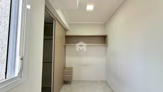 Hall de corredor com paredes brancas e prateleira de madeira.