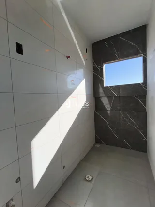 Hallway com revestimento de cerâmica branca e parede de mármore escura.