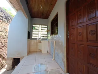 Hall de entrada com piso de cerâmica e parede de tijolo aparente.