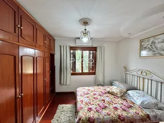Quarto com armários de madeira e cama decorada em Lajeado, Brasil.