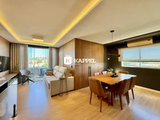 Sala de estar com sofá e mesa de jantar em um ambiente moderno com vista para o exterior.