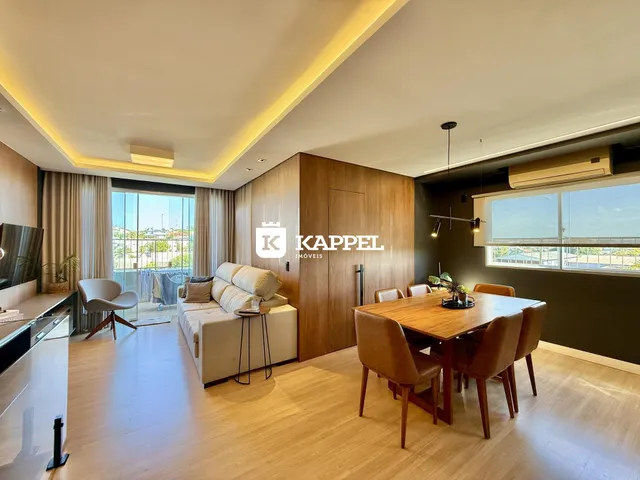 Sala de estar com sofá e mesa de jantar em um ambiente moderno com vista para o exterior.