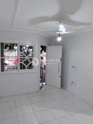 Foto do interior de uma sala com piso de cerâmica e janela.