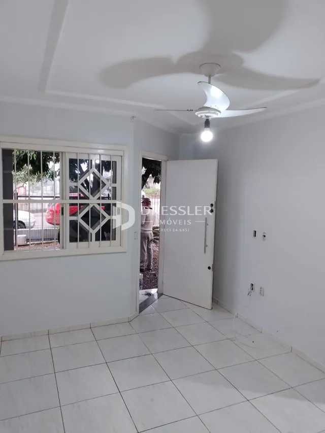 Foto do interior de uma sala com piso de cerâmica e janela.