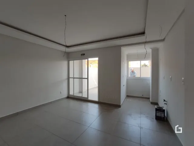 Vista interna de um ambiente com paredes brancas e piso claro.