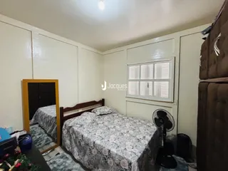 Quarto com cama e armário visíveis na sala.