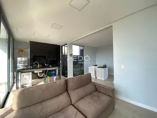 Sala de estar com sofá e área de cozinha em um imóvel no Brasil.