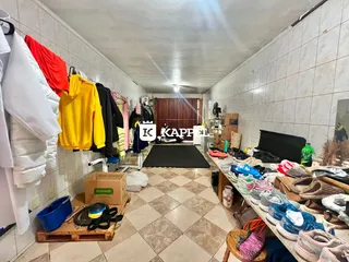 Hall de entrada com roupas penduradas e piso de cerâmica.
