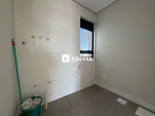 Hall de entrada com paredes brancas e janela de vista.