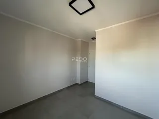 Hall de entrada com paredes brancas e piso cinza.