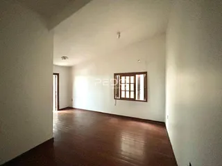 Hall de entrada com piso de madeira e parede branca.