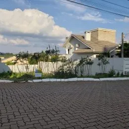 Fachada de uma residência em Lajeado, Brasil, com muro frontal e área pavimentada.