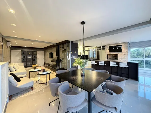 Interior moderno de uma sala de estar e jantar com piso claro e móveis contemporâneos.