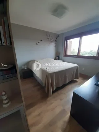 Quarto com cama e piso de madeira clara.