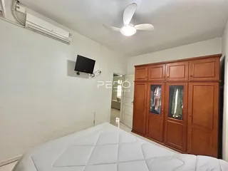 Quarto com cama e armário de madeira no interior da residência.