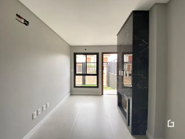 Hall de entrada com piso claro e paredes brancas.