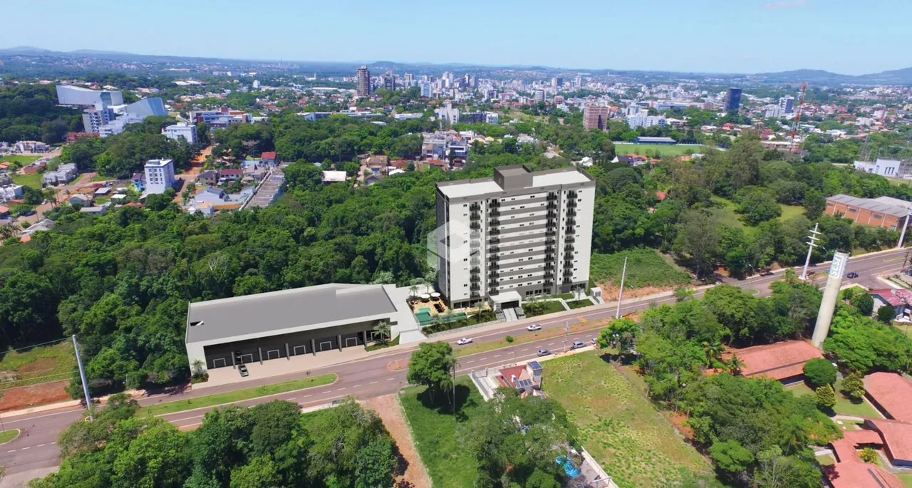 Vista aérea de um edifício residencial cercado por vegetação densa.