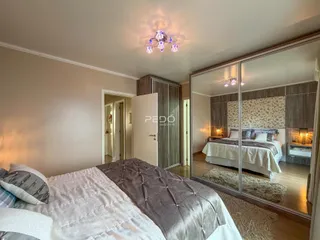 Quarto com cama grande e piso de madeira em um imóvel no Brasil.