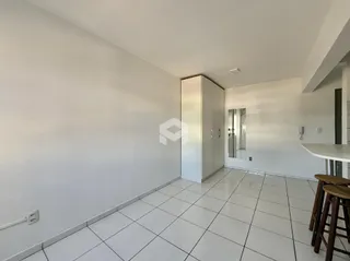 Corredor interno com piso de cerâmica branca.