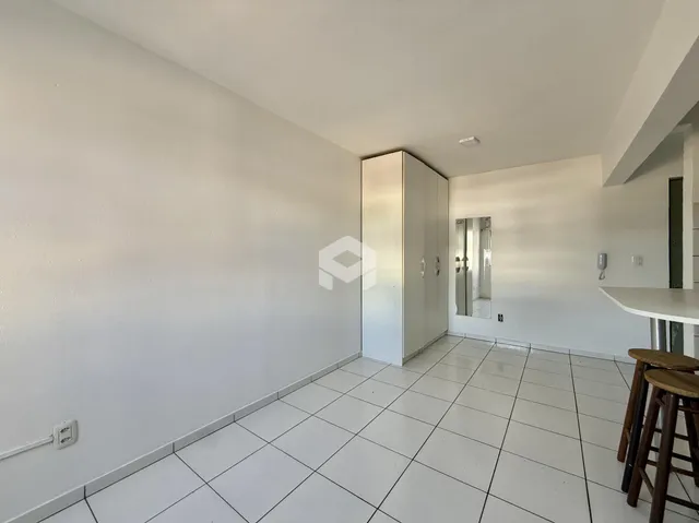 Corredor interno com piso de cerâmica branca.