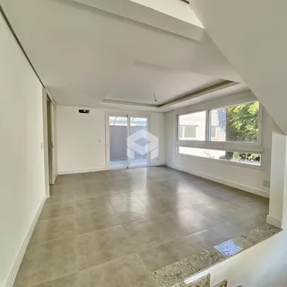 Sala de estar com piso de cerâmica clara e grandes janelas.