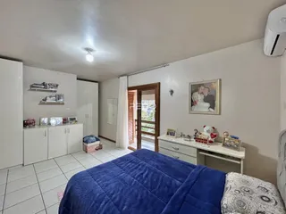 Quarto com armários brancos e piso de cerâmica.