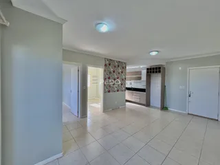 Ambiente interno de uma sala com piso de cerâmica clara e portas de acesso.
