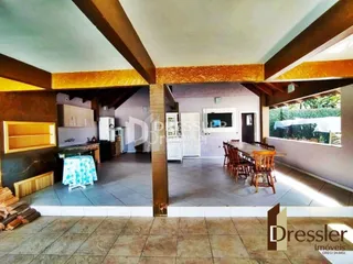 Espaço interno com vigas de madeira e piso de cerâmica.