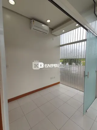Hall de entrada com paredes brancas e piso de cerâmica claro.