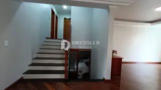 Corredor com escadas de madeira em uma residência.