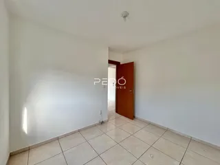 Hall de entrada com piso de cerâmica claro e porta de madeira.