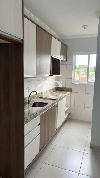 Foto interna de uma cozinha com armários superiores e inferiores e bancada de granito.