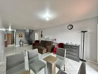Sala de estar e jantar com sofá e mesa de vidro em um apartamento.