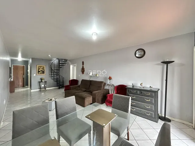 Sala de estar e jantar com sofá e mesa de vidro em um apartamento.