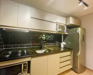 Foto de uma cozinha moderna com armários brancos e bancadas escuras.