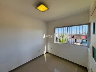Vista interna de um ambiente com paredes brancas e piso de cerâmica.