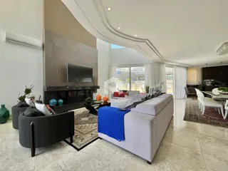 Sala de estar moderna com lareira e sofá grande em um imóvel no Brasil.