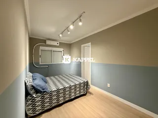 Quarto com cama de casal e janela com persianas em um imóvel em Lajeado.