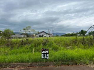 Vista da fachada de uma propriedade em Lajeado, Brasil, cercada por vegetação alta.