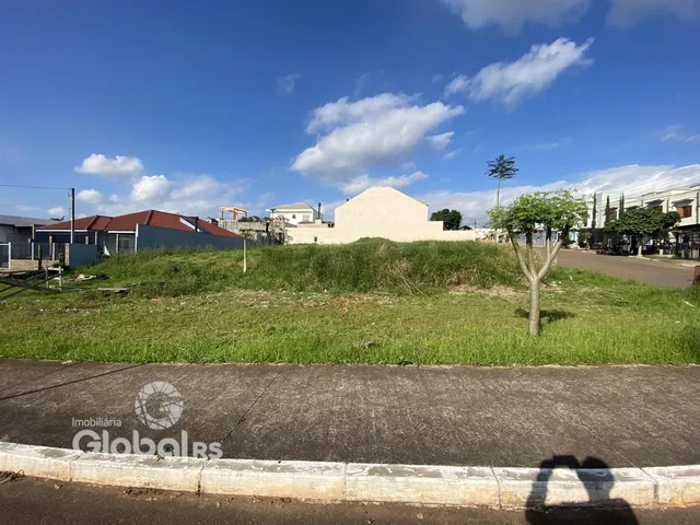 Vista externa de uma propriedade com gramado e vegetação ao lado de uma estrada.
