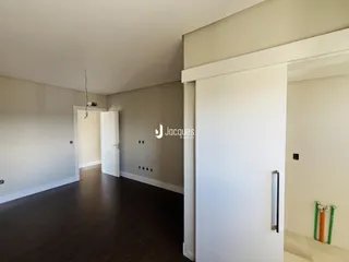 Hall de entrada com piso de madeira escura.