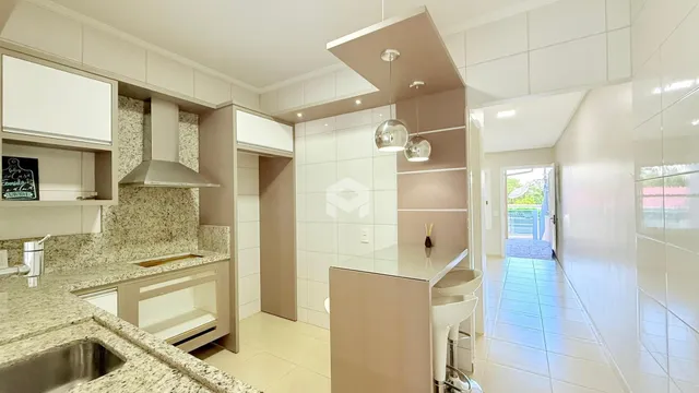 Foto de uma cozinha moderna com armários brancos e bancadas de granito.