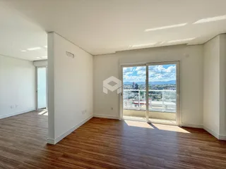 Interior de um ambiente com piso de madeira e vista para a paisagem.