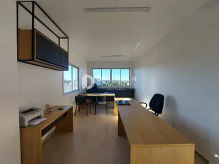Ambiente interno de uma sala de estar com decoração moderna e piso de madeira clara.