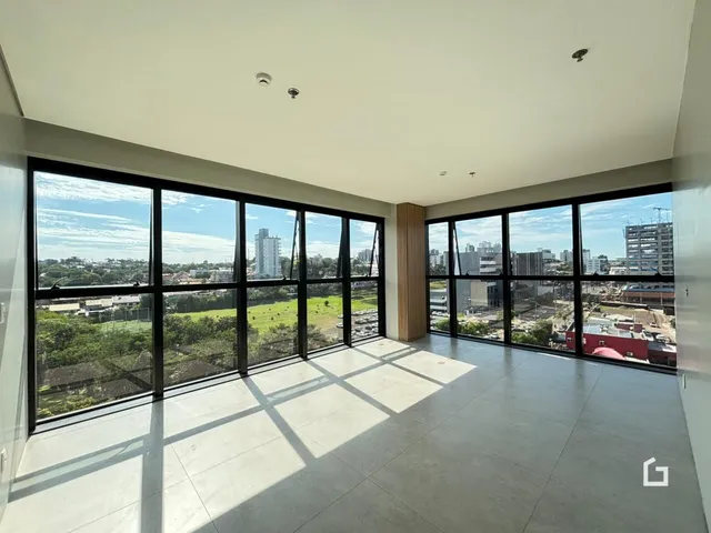 Sala com grandes janelas oferecendo uma vista da paisagem.