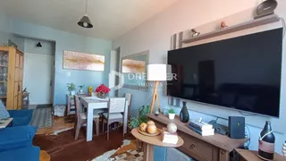 Sala de estar com decoração de madeira e televisão grande.