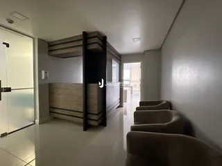 Sala de estar com sofás e paredes brancas em um imóvel no Brasil.