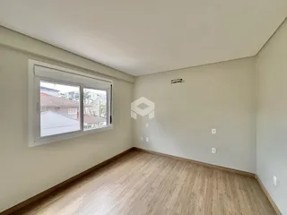 Ambiente interno com piso de madeira clara e grande janela.