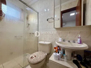 Foto de um banheiro com azulejos brancos e louças sanitárias.